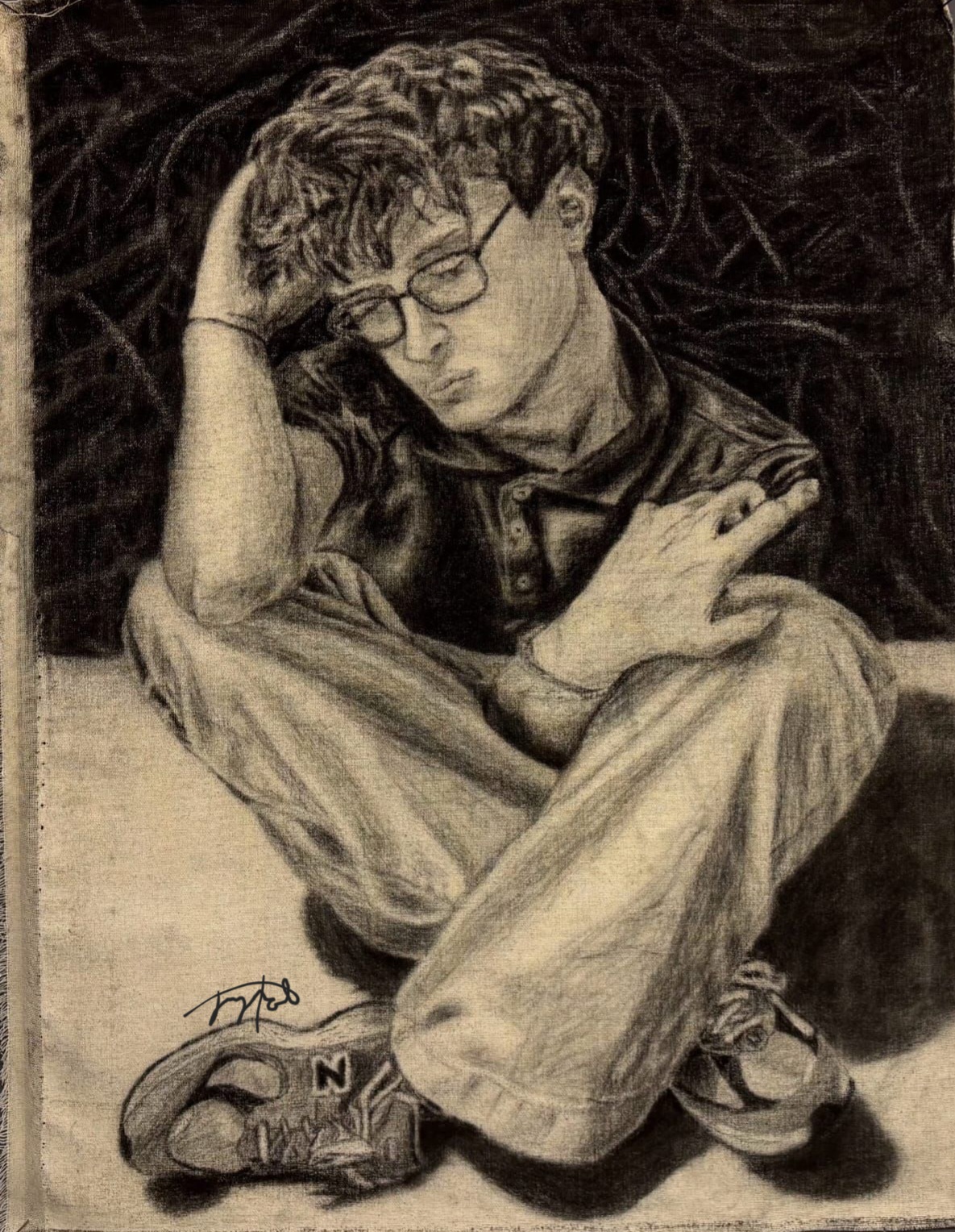 Portrait of Chris seated with arms wrapped around the body.
